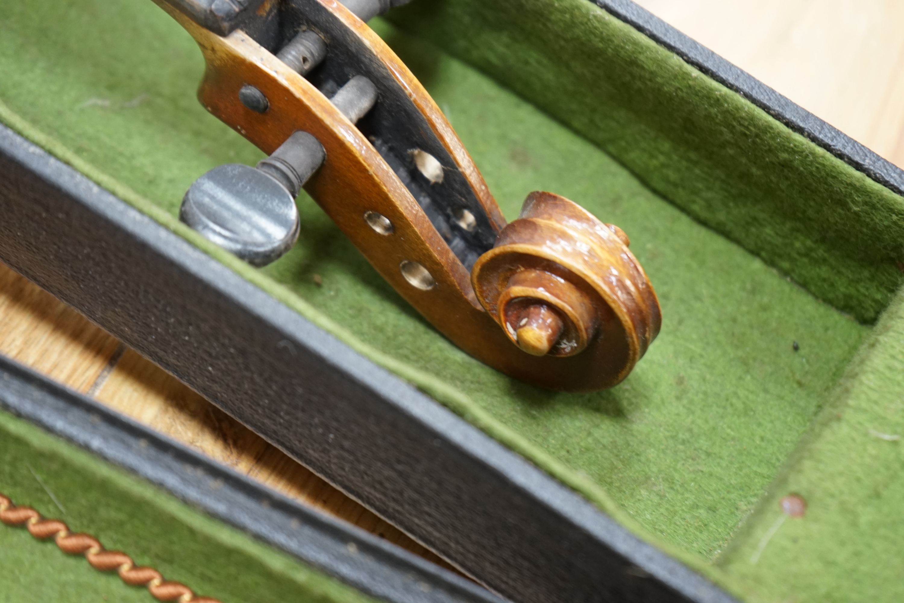 A cased three-quarter size 1920s Czechoslovakian violin, body length 33cm. Condition - fair to good.